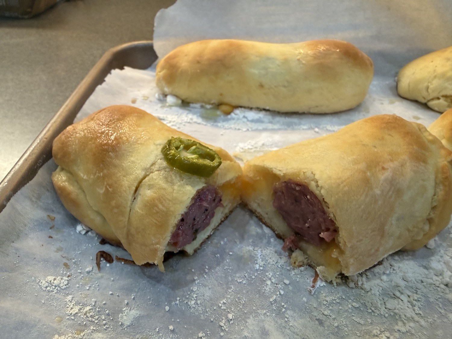 Kolache split open — smoked sausage, cheese, and jalapeño