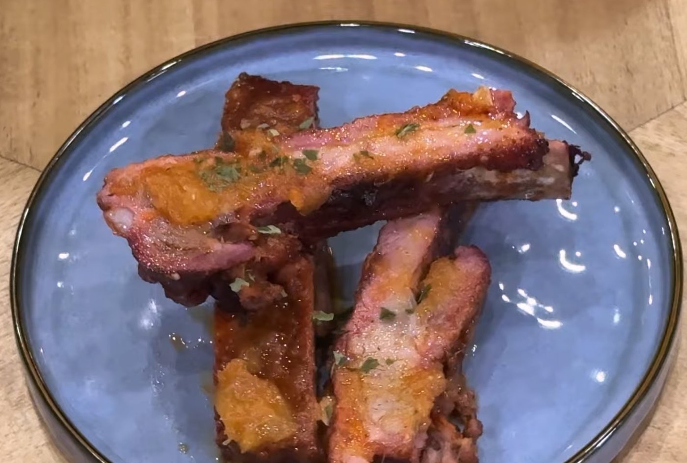 Pineapple BBQ glazed St. Louis pork ribs on a blue plate